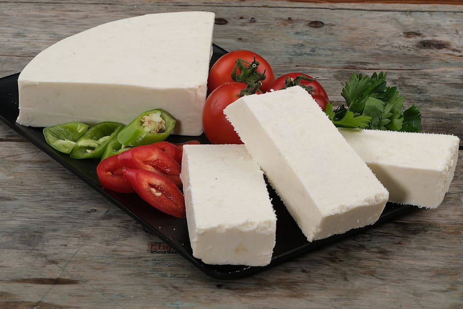 A delicious arrangement of cottage cheese, fresh tomatoes, and peppers on a rustic wooden surface.