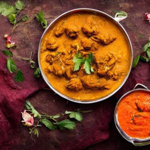 Pyszne indyjskie danie curry ze świeżymi ziołami, soczystymi kolorami i przyprawami.