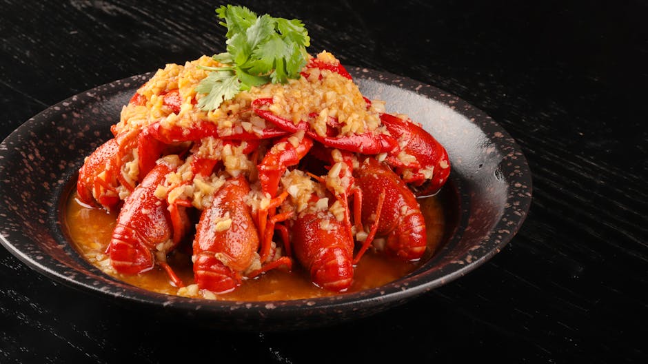 Pyszny homar w sosie czosnkowym, podawany z kolendrą na czarnym ceramicznym talerzu.