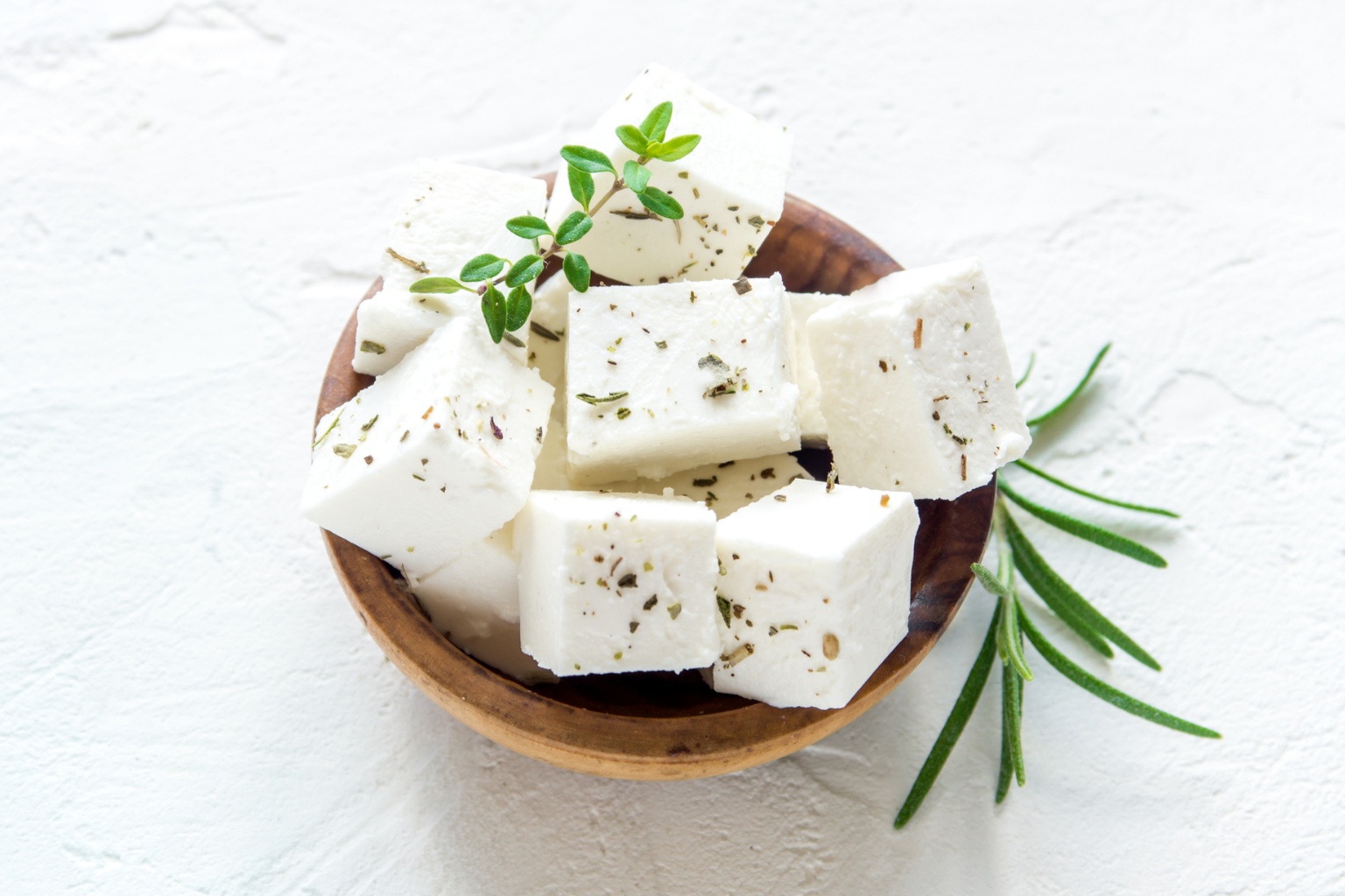 Ser feta na drewnianej miseczce z ziołami