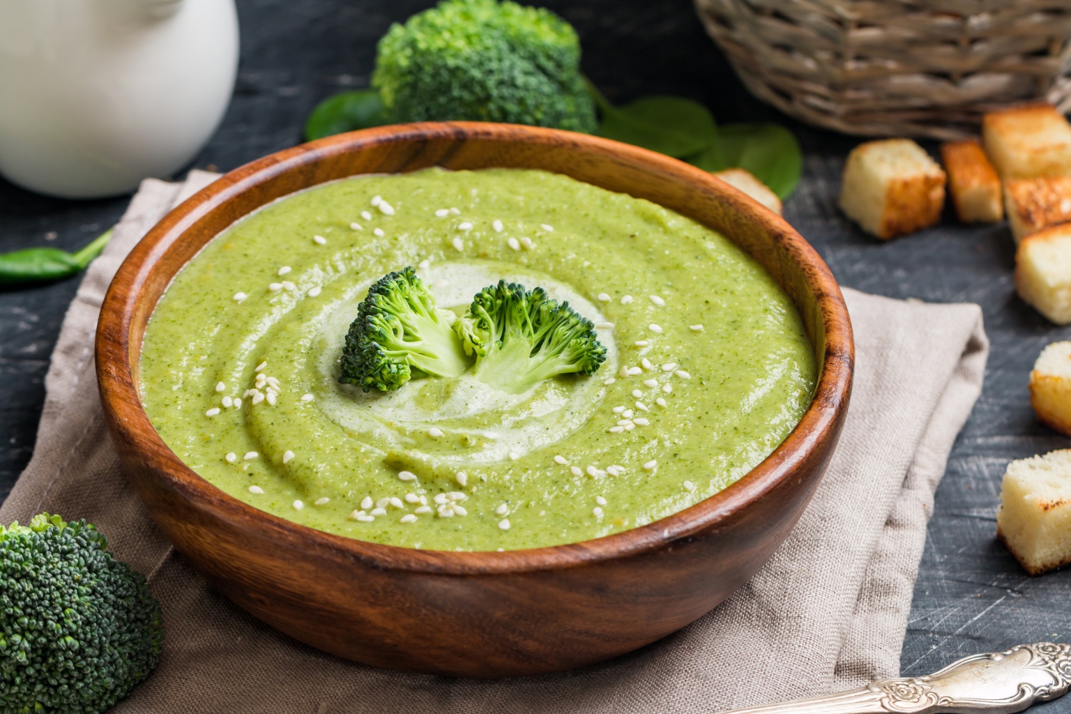 Krem z brokuła z dodatkiem sezamu w drewnianej misce.