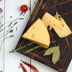 Masdamer z ziołami na drewnianej desce degustacyjnej.