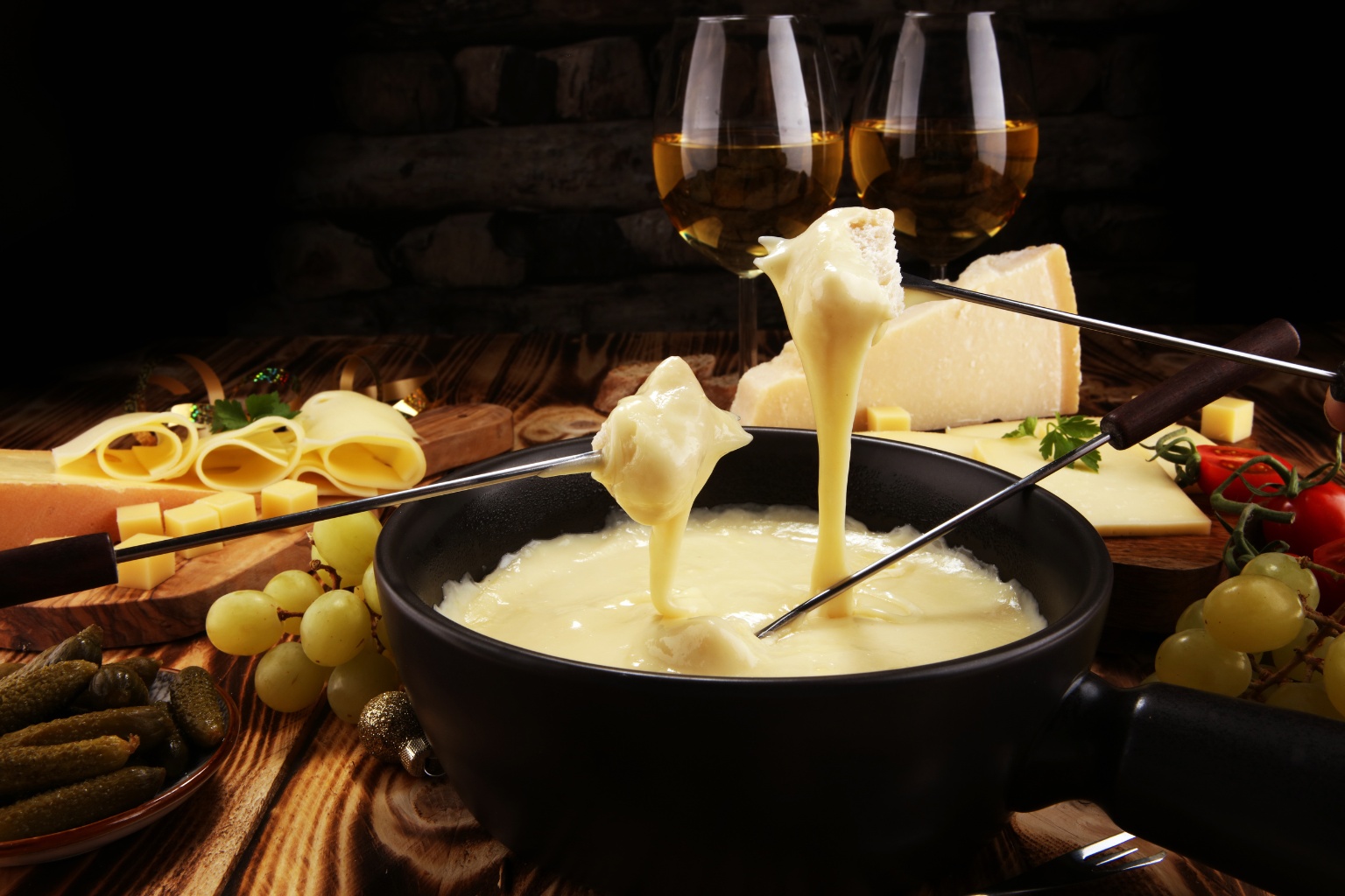 Fondue serowe z masdamerem i dodatkami w postaci warzyw i owoców.