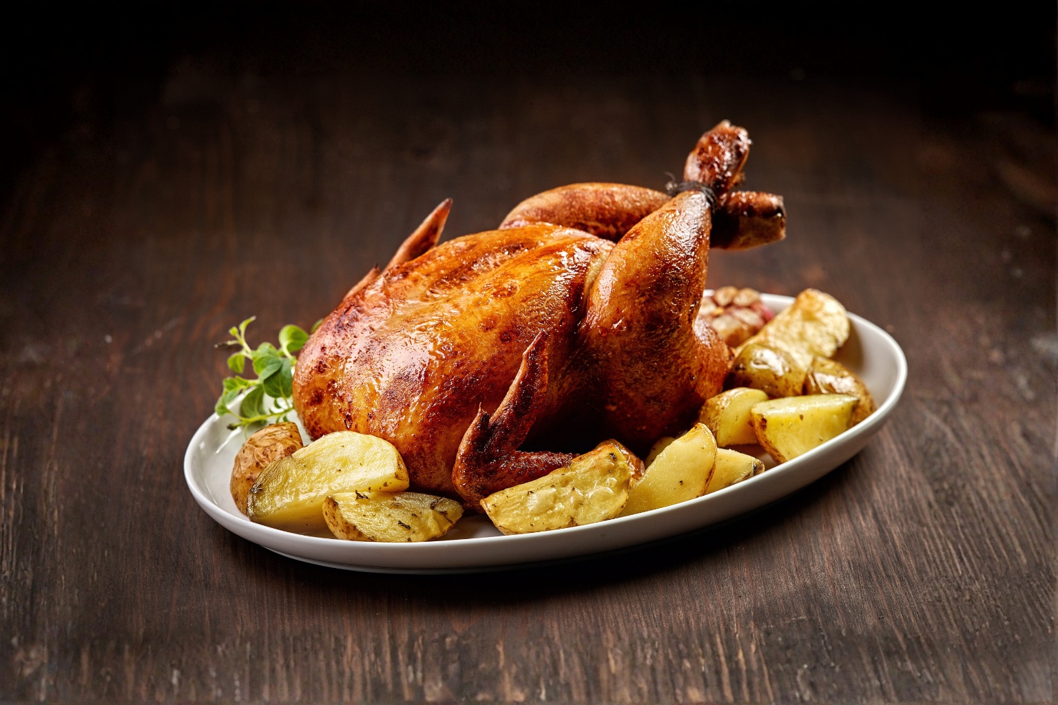 Pieczony kurczak w całości z pieczonymi ziemniakami.