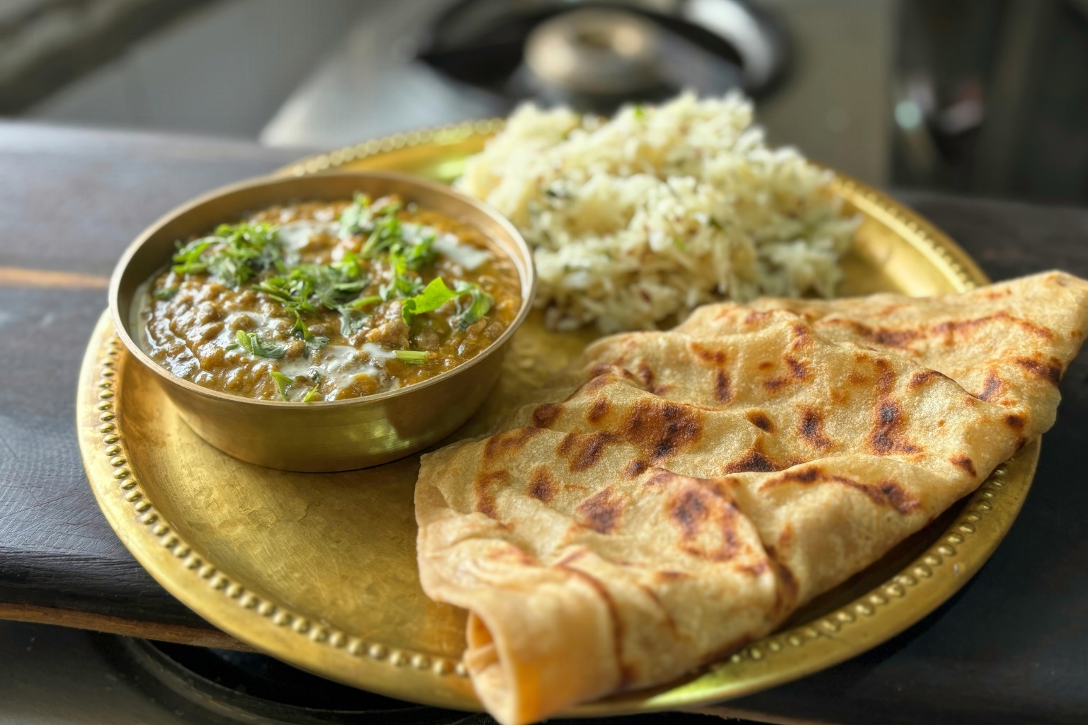 Aromatyczne danie kuchni indyjskiej z ryżem basmati, soczewicowym curry i chlebkiem naan, w którym wyraźnie wyczuwalny jest kardamon nadający potrawie korzenną głębię i świeżą nutę.