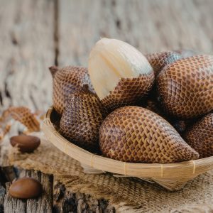 salak w drewnianym naczyniu, którego skórka przypomina łuski smoka
