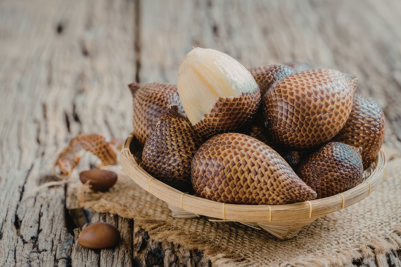 salak w drewnianym naczyniu, którego skórka przypomina łuski smoka