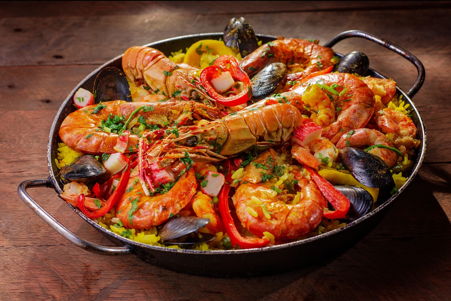 Paella mixta z owocami morza. Hiszpańskie danie z ryżem, szafranem i dodatkami.