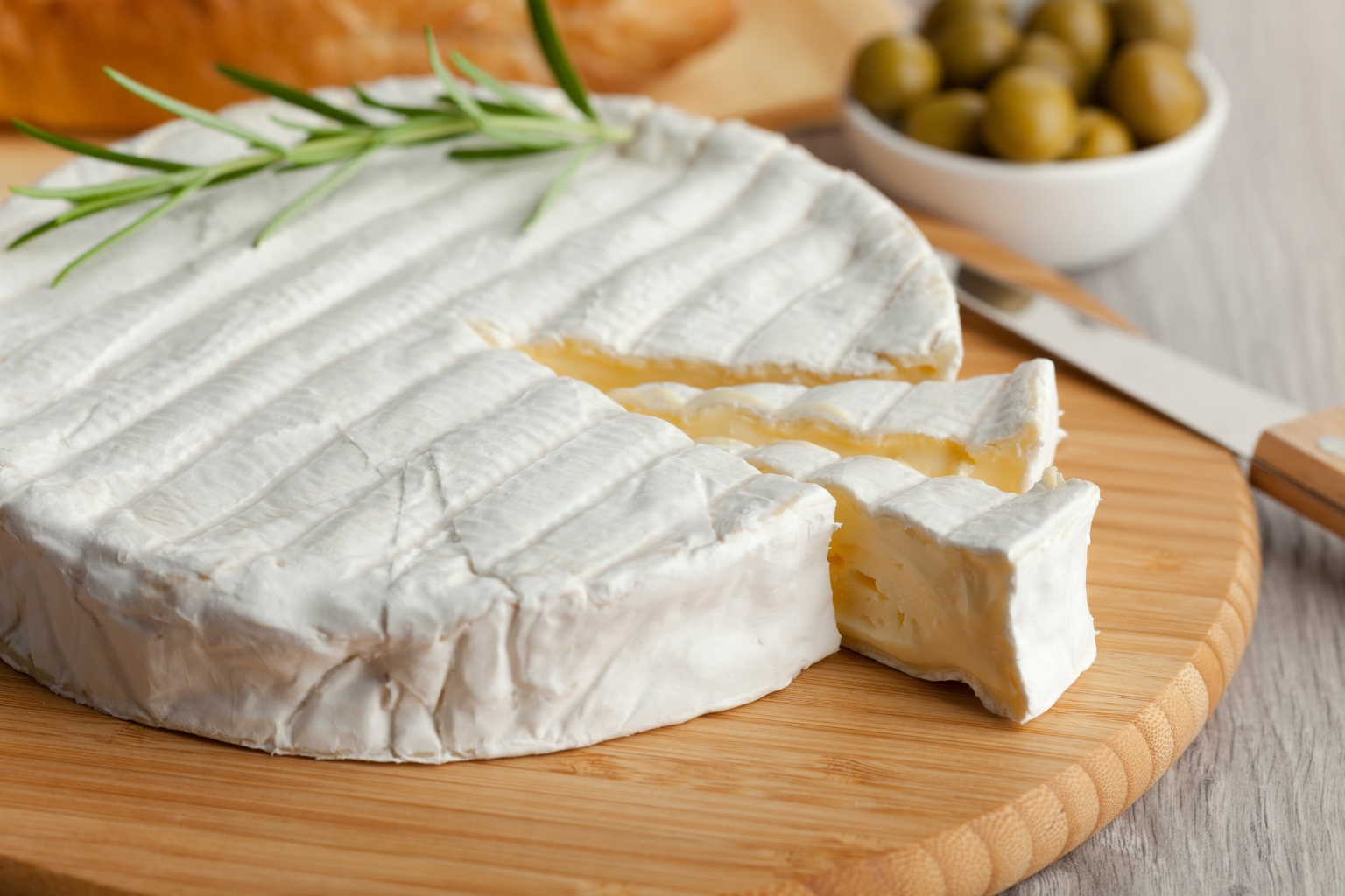 duży, płaski brie na drewnianej desce
